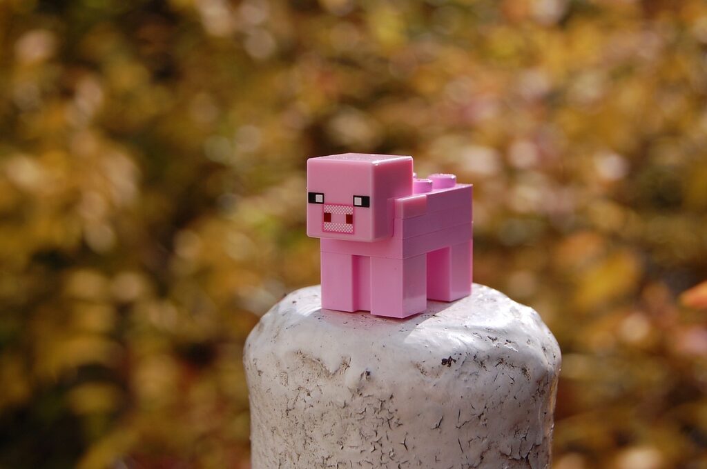 a pink pig is sitting on top of a wooden post
