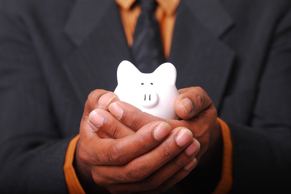 a man in a suit holding a piggy bank