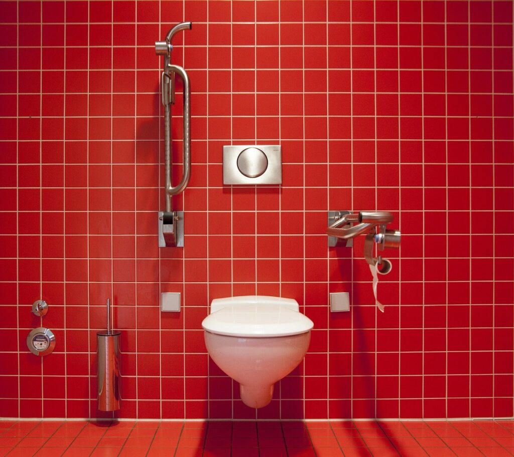a red tiled bathroom with a toilet and shower