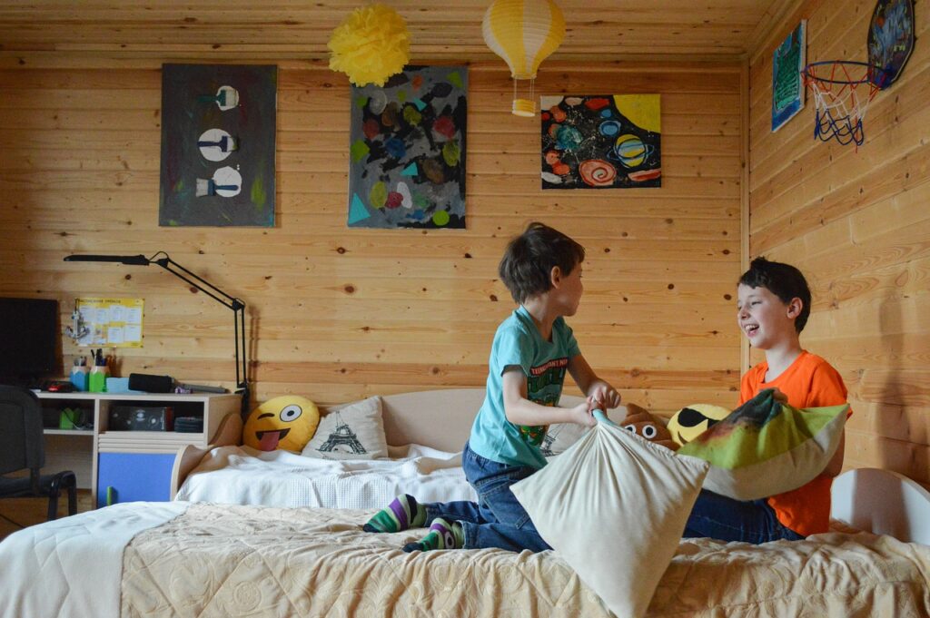 two boys playing on a bed