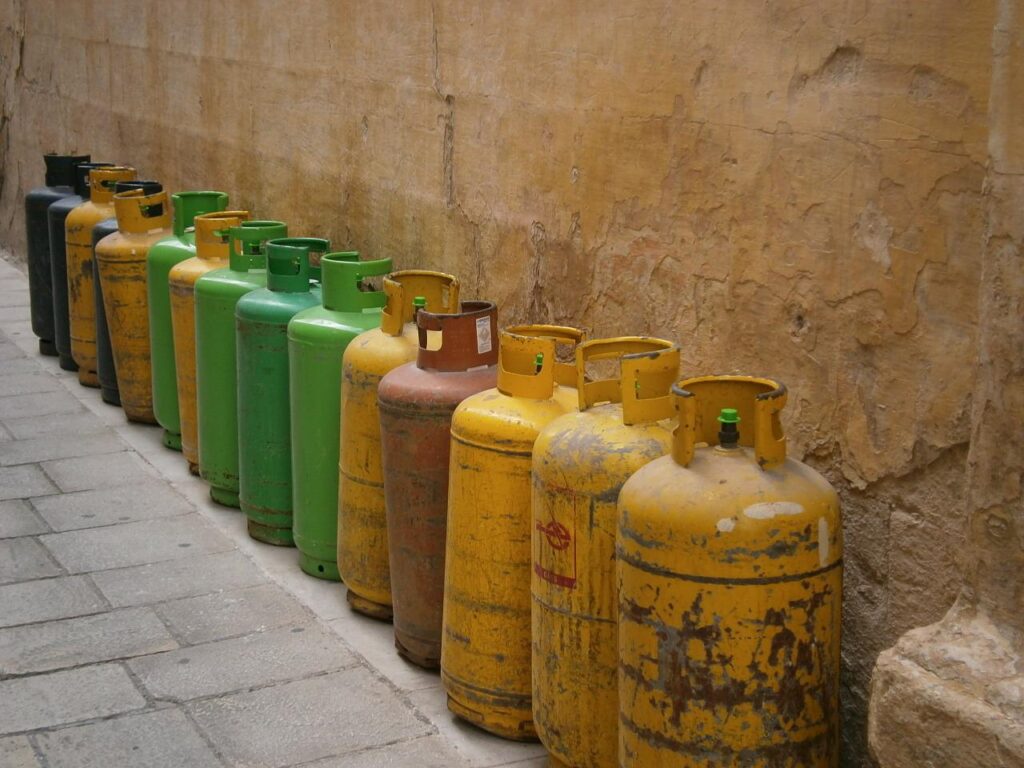 a row of gas bottles lined up against a wall