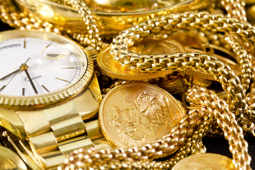 gold jewelry and watches are scattered around a table