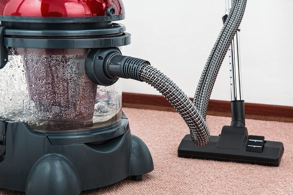 a vacuum cleaner sitting on the floor next to a carpet