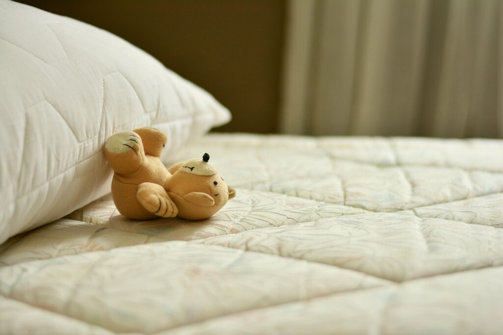 a teddy bear sitting on a bed