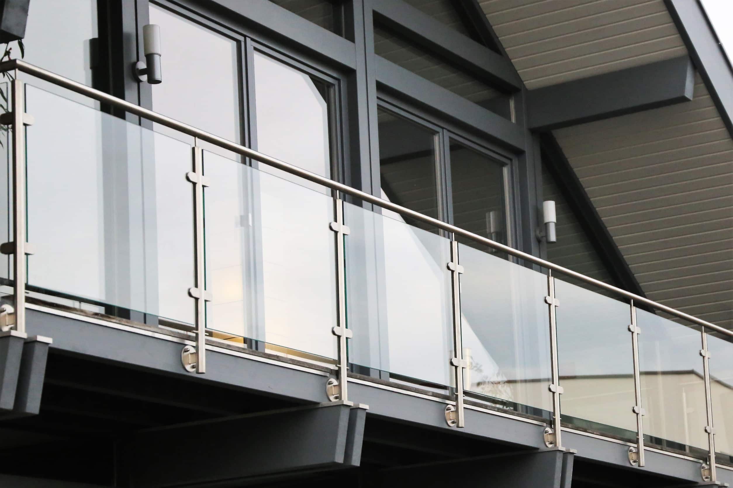 a glass balustrade on a building with a metal railing