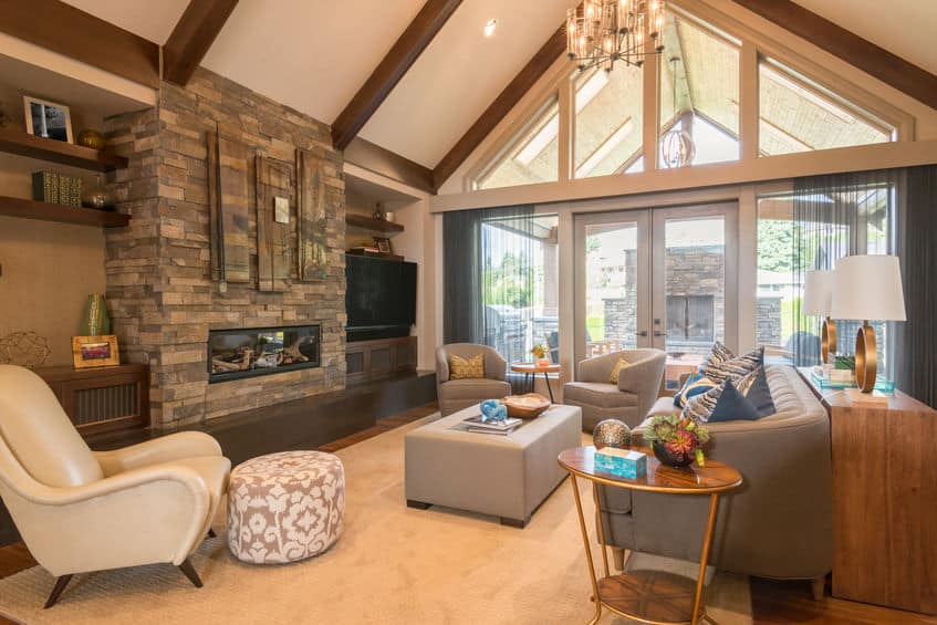 a living room with a vaulted ceiling and a stone fireplace